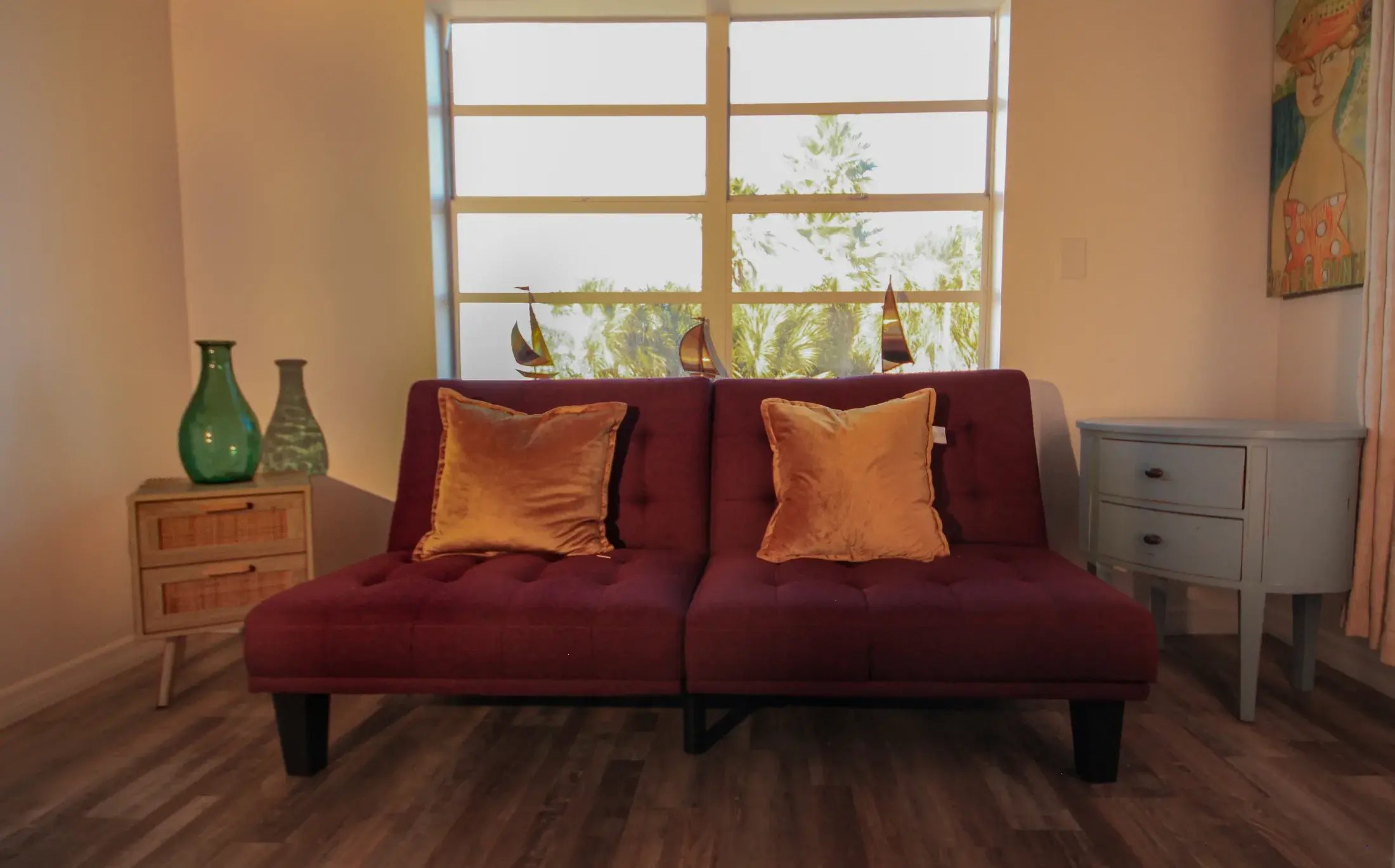 Fold-out futon area with window light and simple coastal decor.