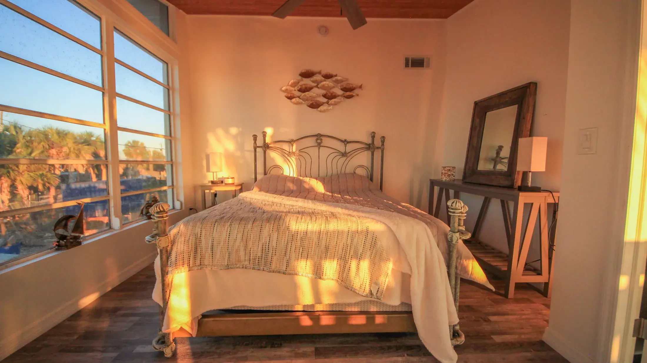 Primary bedroom with queen bed and warm evening light.